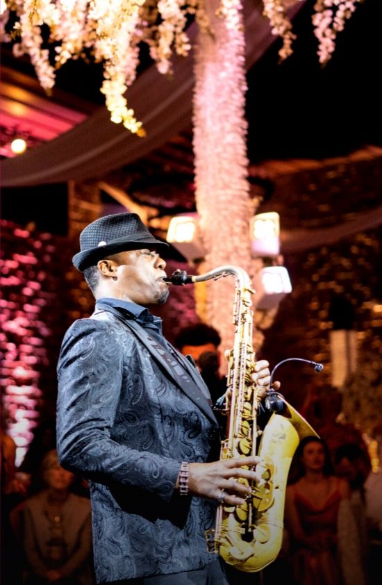 Saxy Rob playing under hanging florals